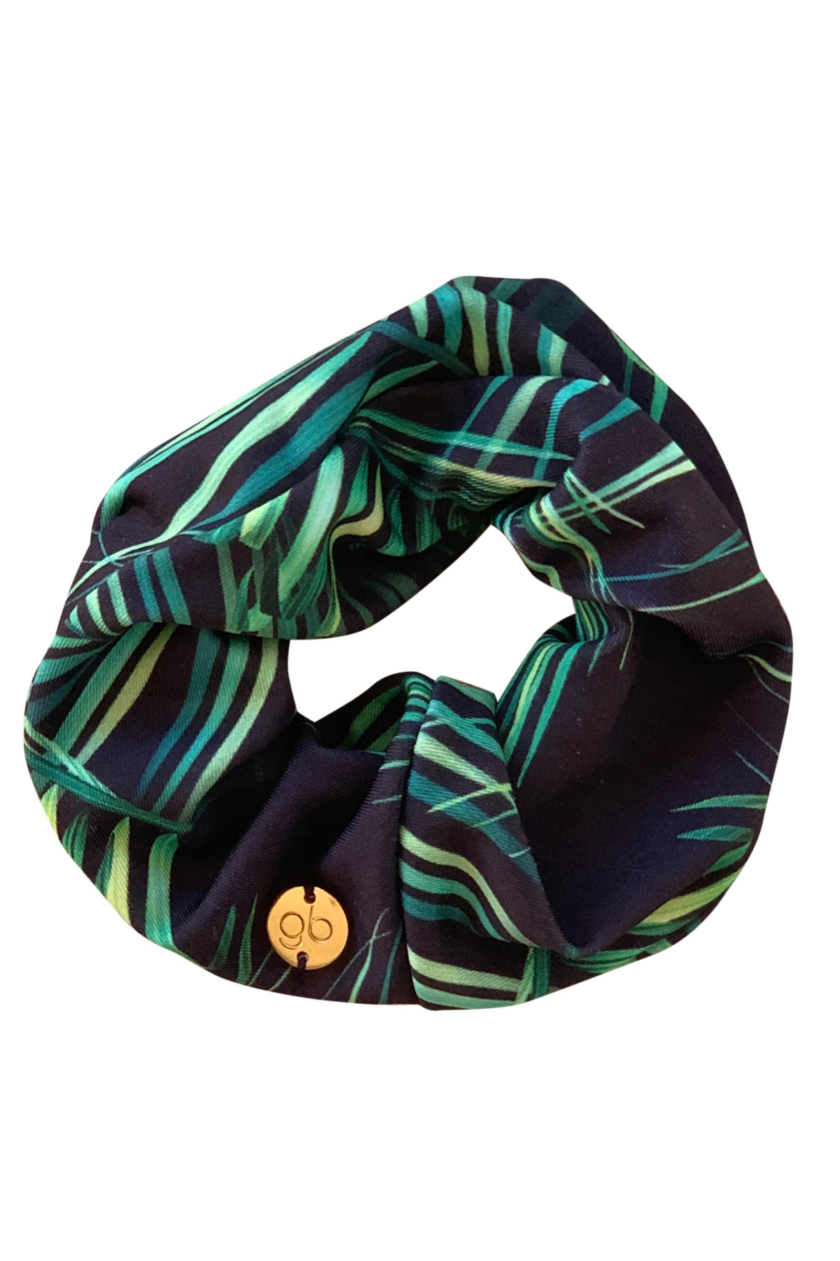 Green and black patterned scrunchie with a button on a white background